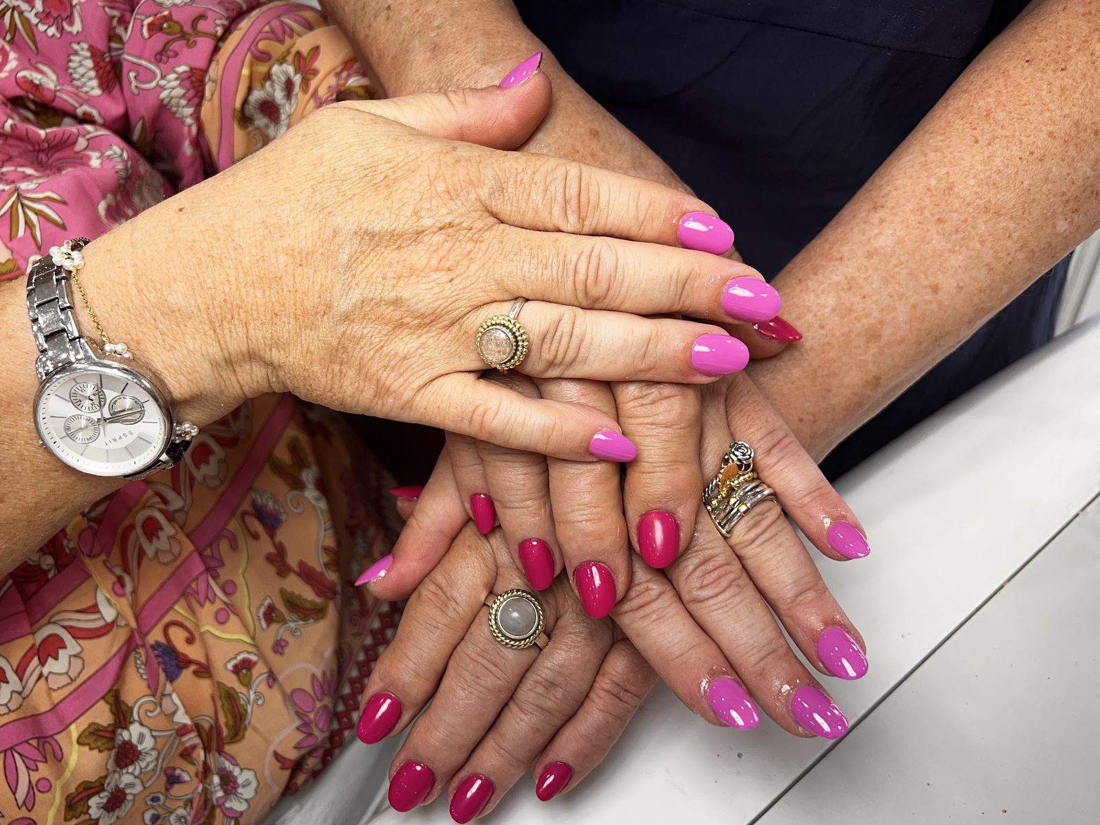 Twee paar handen met roze en magenta gellak