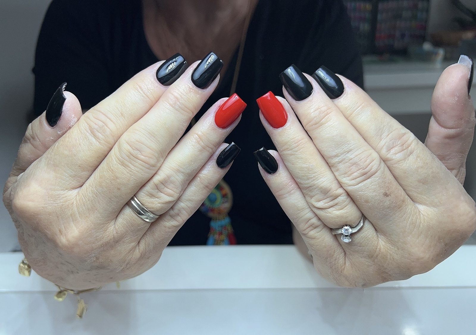 Glanzende zwarte nagels met twee rode accentnagels